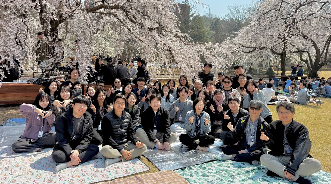 Lab group photo under cherry blossoms at the spring picnic